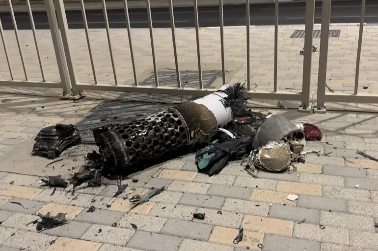The remnants of an Iranian missile intercepted over Qatar as it lies on a pavement near a fence are seen on June 23 2025 AFPTV