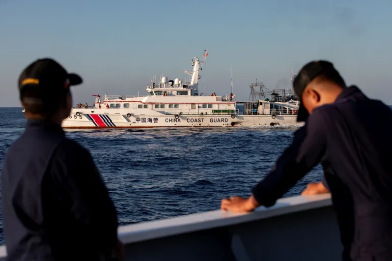Members of the Philippine Coast Guard stand alert as a China Coast Guard vessel blocks their way to a resupply mission at Second Thomas Shoal in the South China Sea